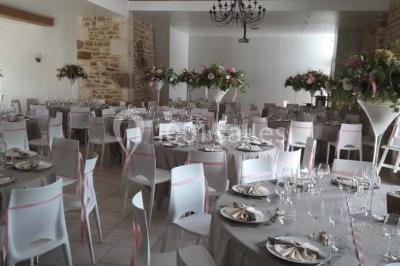 Chambre mansardée avec quatre lits simples, couvertures bleues et étagère en bois clair contre un mur gris.