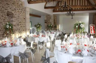 Chambre mansardée avec quatre lits simples, couvertures bleues et étagère en bois clair contre un mur gris.