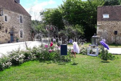 Chambre mansardée avec quatre lits simples, couvertures bleues et étagère en bois clair contre un mur gris.
