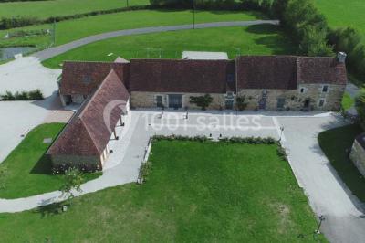 Chambre mansardée avec quatre lits simples, couvertures bleues et étagère en bois clair contre un mur gris.