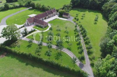 Chambre mansardée avec quatre lits simples, couvertures bleues et étagère en bois clair contre un mur gris.