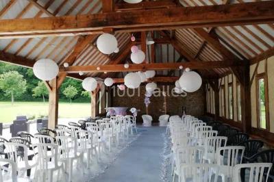 Chambre mansardée avec quatre lits simples, couvertures bleues et étagère en bois clair contre un mur gris.