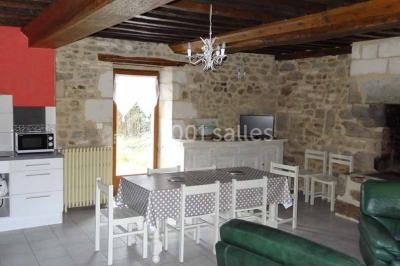 Chambre mansardée avec quatre lits simples, couvertures bleues et étagère en bois clair contre un mur gris.