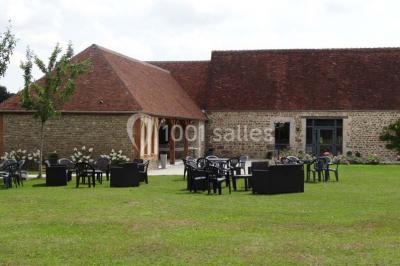 Chambre mansardée avec quatre lits simples, couvertures bleues et étagère en bois clair contre un mur gris.