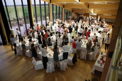 Cabane en bois arrondie dans un champ verdoyant sous un ciel bleu clair.