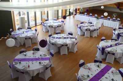 Cabane en bois arrondie dans un champ verdoyant sous un ciel bleu clair.