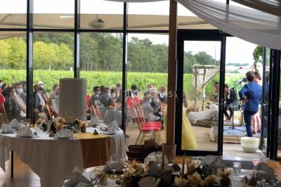 Cabane en bois arrondie dans un champ verdoyant sous un ciel bleu clair.