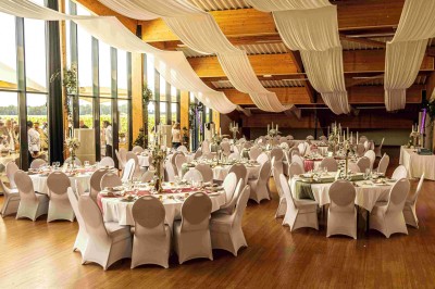 Cabane en bois arrondie dans un champ verdoyant sous un ciel bleu clair.