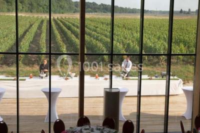 Salle lumineuse accueillant un salon avec des stands, des visiteurs et des tables exposant divers produits et services.