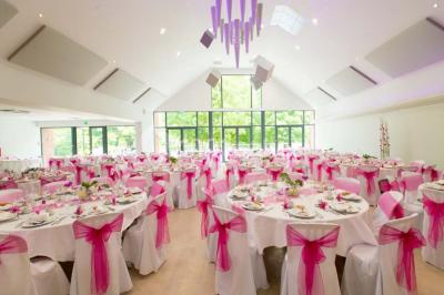Deux lits simples en bois avec couvre-lits bleus dans une chambre mansardée aux murs bleus et parquet au sol.