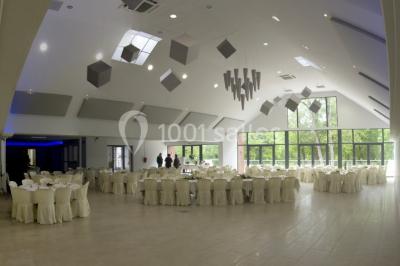Deux lits simples en bois avec couvre-lits bleus dans une chambre mansardée aux murs bleus et parquet au sol.