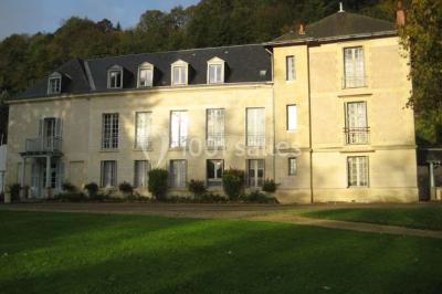 Deux lits simples en bois avec couvre-lits bleus dans une chambre mansardée aux murs bleus et parquet au sol.
