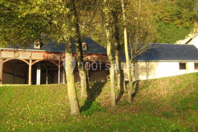 Deux lits simples en bois avec couvre-lits bleus dans une chambre mansardée aux murs bleus et parquet au sol.