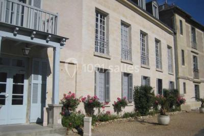 Deux lits simples en bois avec couvre-lits bleus dans une chambre mansardée aux murs bleus et parquet au sol.