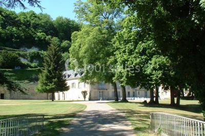 Deux lits simples en bois avec couvre-lits bleus dans une chambre mansardée aux murs bleus et parquet au sol.