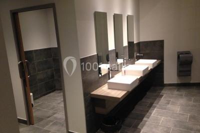 Deux lits simples en bois avec couvre-lits bleus dans une chambre mansardée aux murs bleus et parquet au sol.