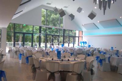 Deux lits simples en bois avec couvre-lits bleus dans une chambre mansardée aux murs bleus et parquet au sol.