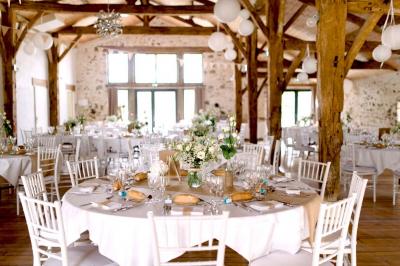 Vue aérienne d'une propriété rurale avec plusieurs bâtiments, une piscine, une tente blanche et des champs environnants.