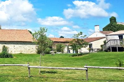 Vue aérienne d'une propriété rurale avec plusieurs bâtiments, une piscine, une tente blanche et des champs environnants.