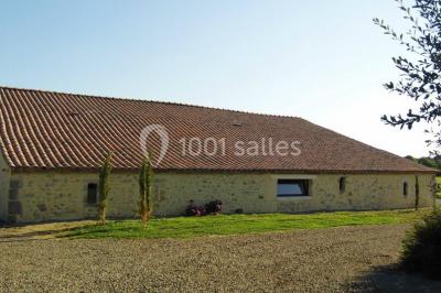 Vue aérienne d'une propriété rurale avec plusieurs bâtiments, une piscine, une tente blanche et des champs environnants.