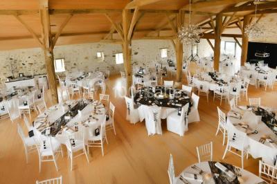 Vue aérienne d'une propriété rurale avec plusieurs bâtiments, une piscine, une tente blanche et des champs environnants.