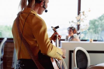 Une femme en tenue noire porte deux plateaux de hors-d'œuvre devant une porte rouge ouverte.
