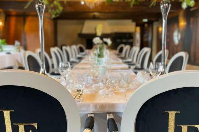 Une femme en tenue noire porte deux plateaux de hors-d'œuvre devant une porte rouge ouverte.