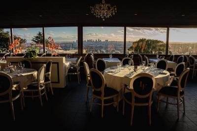 Une femme en tenue noire porte deux plateaux de hors-d'œuvre devant une porte rouge ouverte.