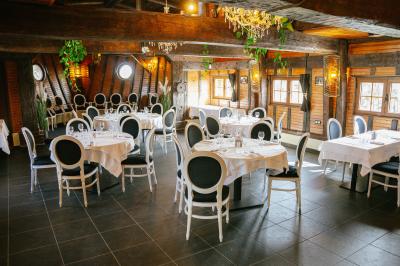 Une femme en tenue noire porte deux plateaux de hors-d'œuvre devant une porte rouge ouverte.