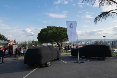 Une femme en tenue noire porte deux plateaux de hors-d'œuvre devant une porte rouge ouverte.