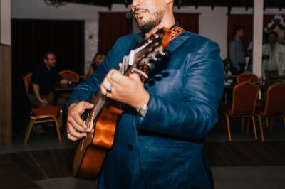 Personne coupant un plat composé de médaillons de viande, légumes rôtis et sauce blanche, servi sur une assiette blanche.