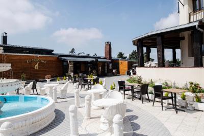 Personne coupant un plat composé de médaillons de viande, légumes rôtis et sauce blanche, servi sur une assiette blanche.