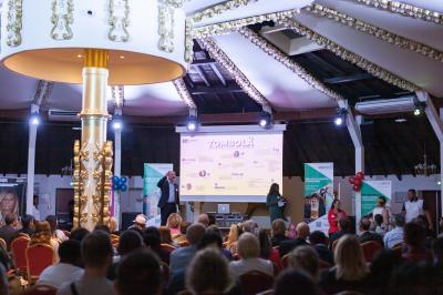 Personne coupant un plat composé de médaillons de viande, légumes rôtis et sauce blanche, servi sur une assiette blanche.