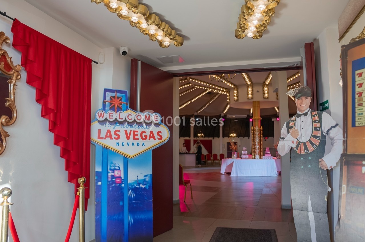 Entrée décorée sur le thème de Las Vegas avec un panneau de bienvenue et des éléments lumineux.