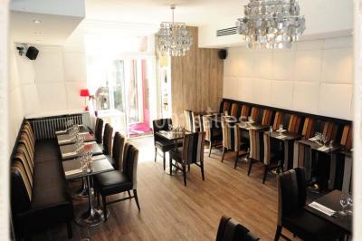 Miniature Location salle Rueil-Malmaison (Hauts-de-Seine) - Restaurant l'Avenue #8 Bar lumineux avec comptoir décoré de bouteilles colorées, entouré de tabourets et d'étagères garnies de bouteilles.