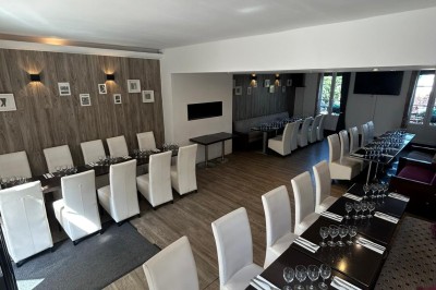 Bar lumineux avec comptoir décoré de bouteilles colorées, entouré de tabourets et éclairé par une lumière douce.