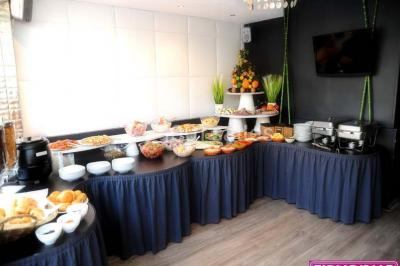 Buffet varié avec plats chauds, salades, pains et fruits, disposé dans une salle élégante avec décoration moderne.