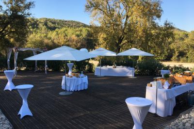 Entrée d'un bâtiment éclairé en soirée, avec des plantes décoratives et des personnes visibles à l'intérieur.