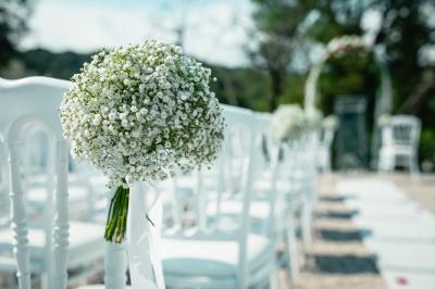 Entrée d'un bâtiment éclairé en soirée, avec des plantes décoratives et des personnes visibles à l'intérieur.