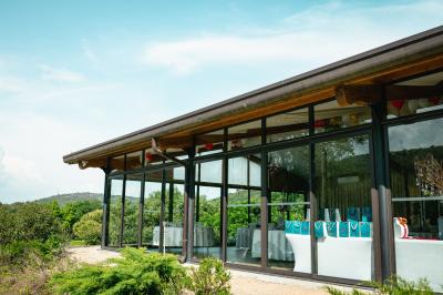 Entrée d'un bâtiment éclairé en soirée, avec des plantes décoratives et des personnes visibles à l'intérieur.