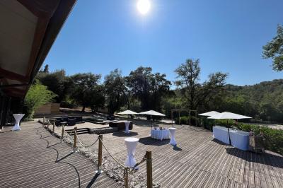 Entrée d'un bâtiment éclairé en soirée, avec des plantes décoratives et des personnes visibles à l'intérieur.