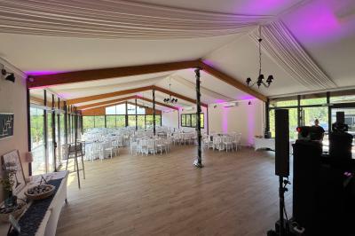Entrée d'un bâtiment éclairé en soirée, avec des plantes décoratives et des personnes visibles à l'intérieur.