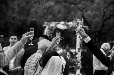 Entrée d'un bâtiment éclairé en soirée, avec des plantes décoratives et des personnes visibles à l'intérieur.