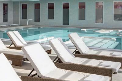 Vue d'une plage à marée basse avec des bouées jaunes et des structures ostréicoles dans une mer calme.