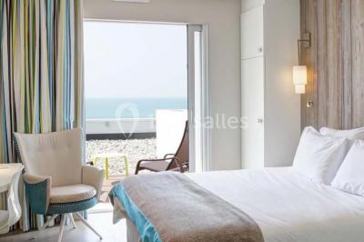 Vue d'une plage à marée basse avec des bouées jaunes et des structures ostréicoles dans une mer calme.