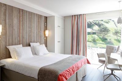 Vue d'une plage à marée basse avec des bouées jaunes et des structures ostréicoles dans une mer calme.