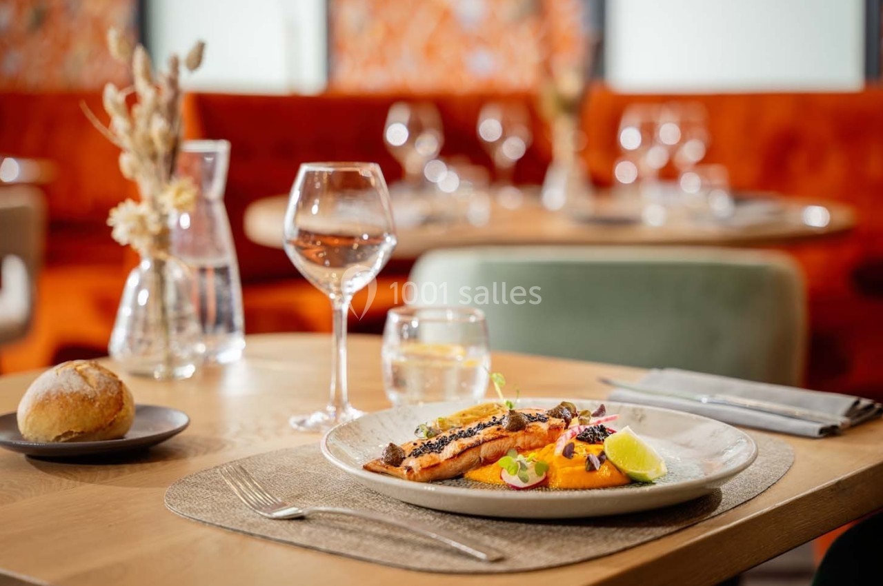 Assiette de saumon grillé avec garniture, servie sur une table dressée dans un restaurant élégant.
