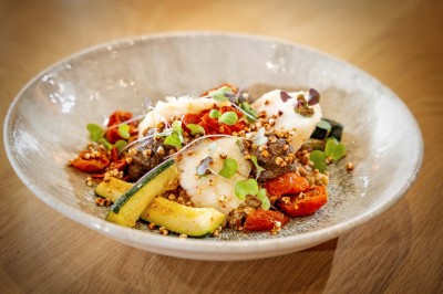 Vue d'une plage à marée basse avec des bouées jaunes et des structures ostréicoles dans une mer calme.