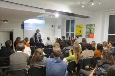 Salle de réunion lumineuse avec une grande table rectangulaire, des chaises noires et des fenêtres donnant sur l'extérieur.