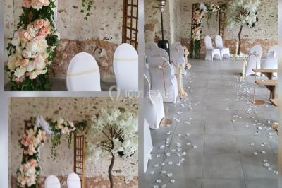 Un couple en tenue de mariage pose sur des rails entourés de verdure dans un cadre naturel et lumineux.